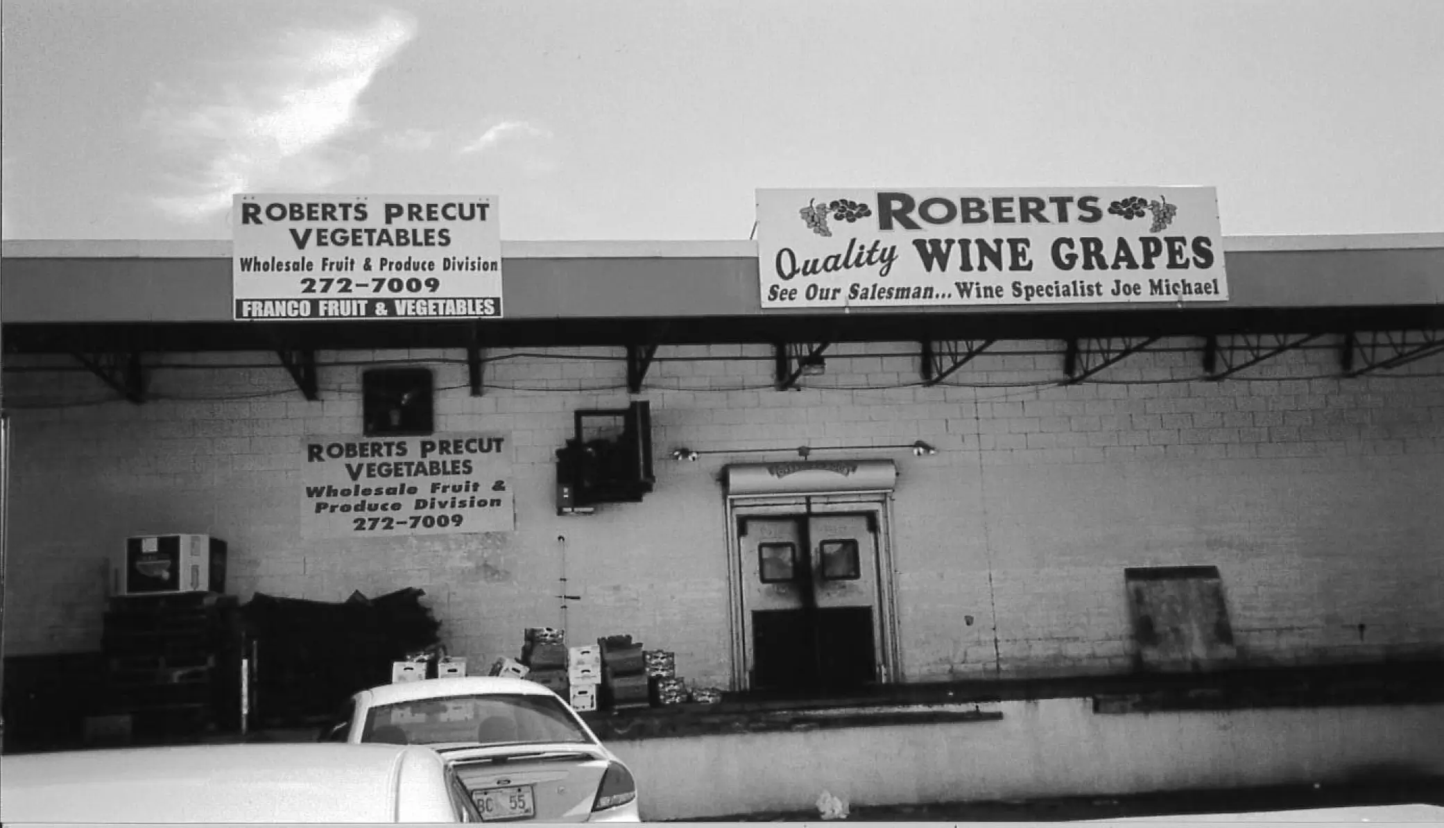 Warehouse exterior with signs for produce sales.